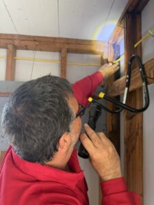 Haynes technician inspecting exposed wood framing for signs of termite activity